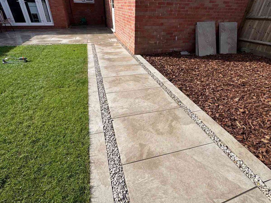 Porcelain paving path with gravel border running alongside a new lawn