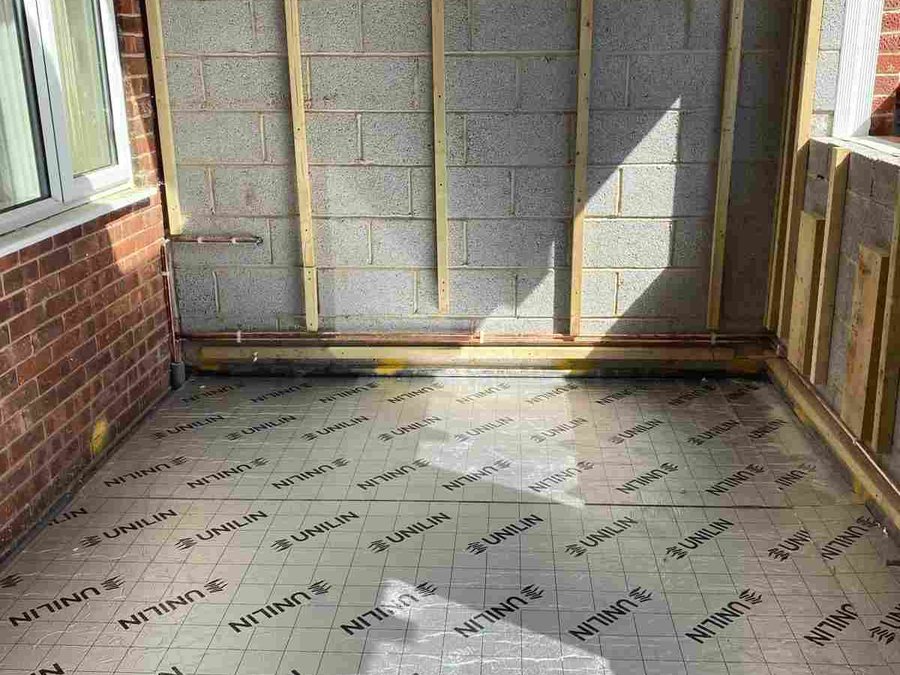 Extension interior during the build, with an insulated floor and blockwork walls