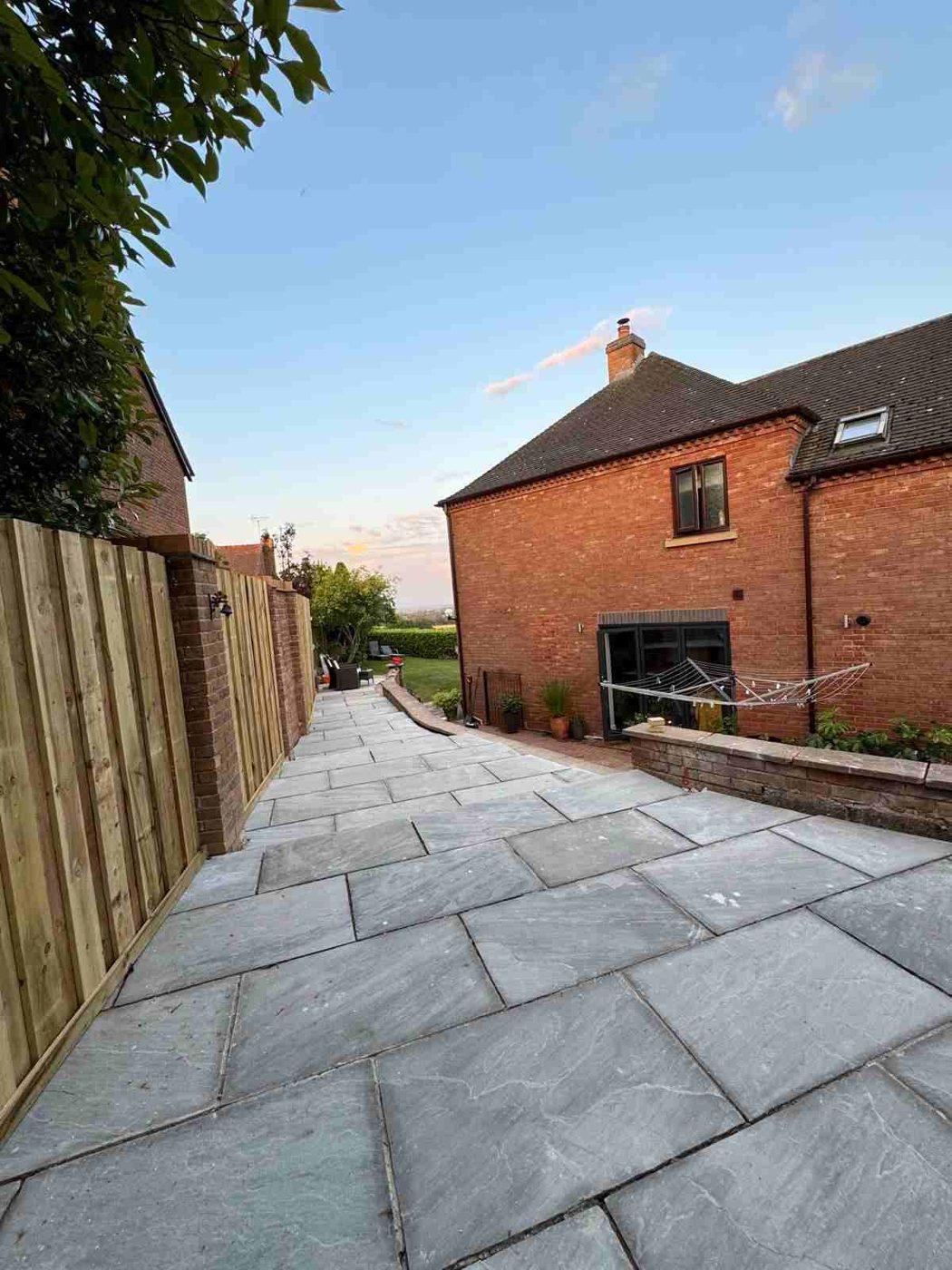 Long view down the tiered sandstone patio towards the house in Bramshall