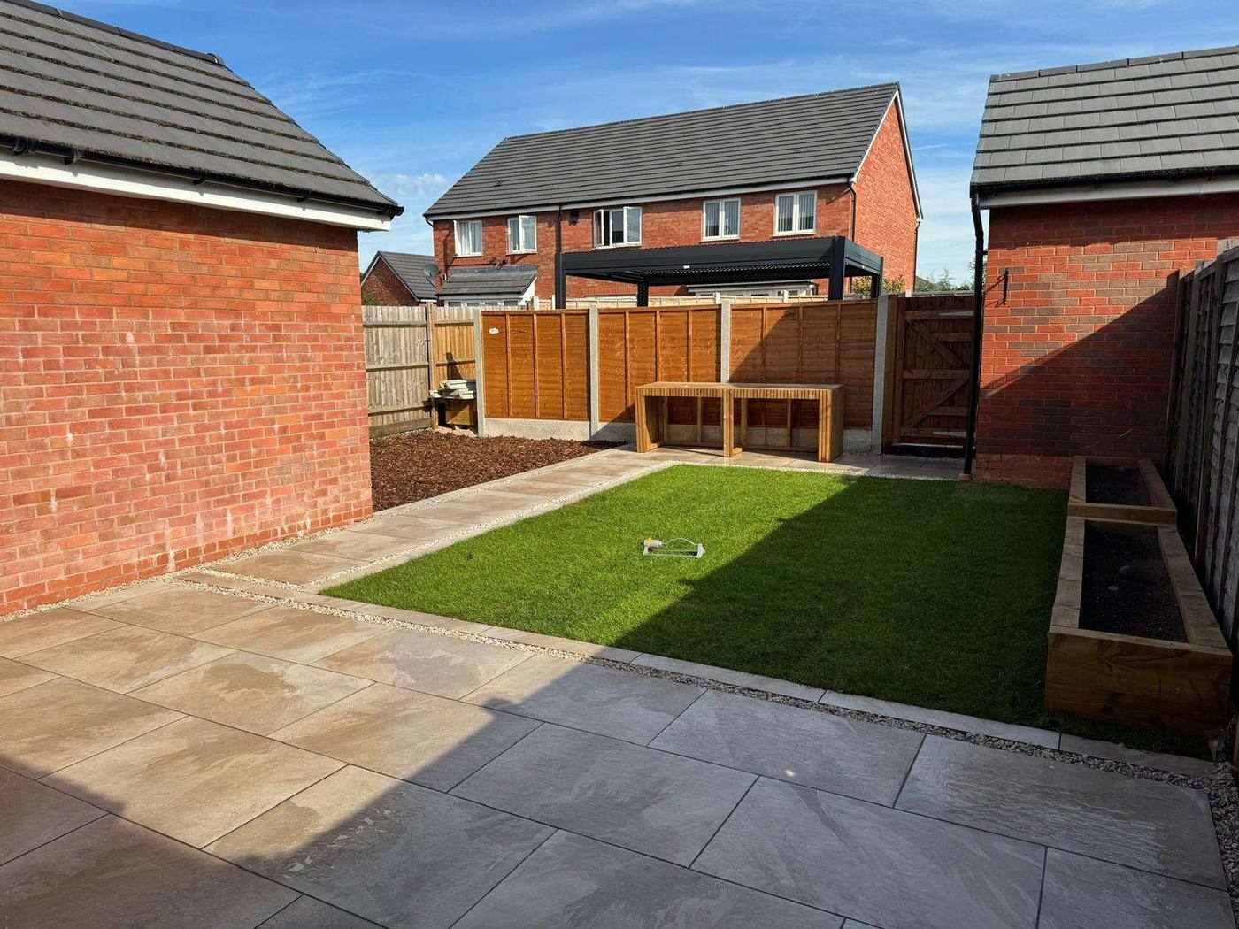 Porcelain walkway leading past the new lawn to a bark-chip play area for the children in Uttoxeter