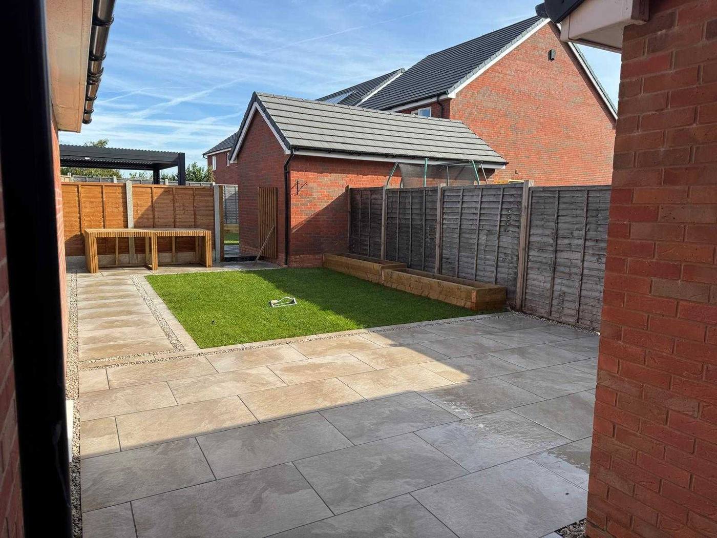 Large beige porcelain patio by the house in a family garden in Uttoxeter