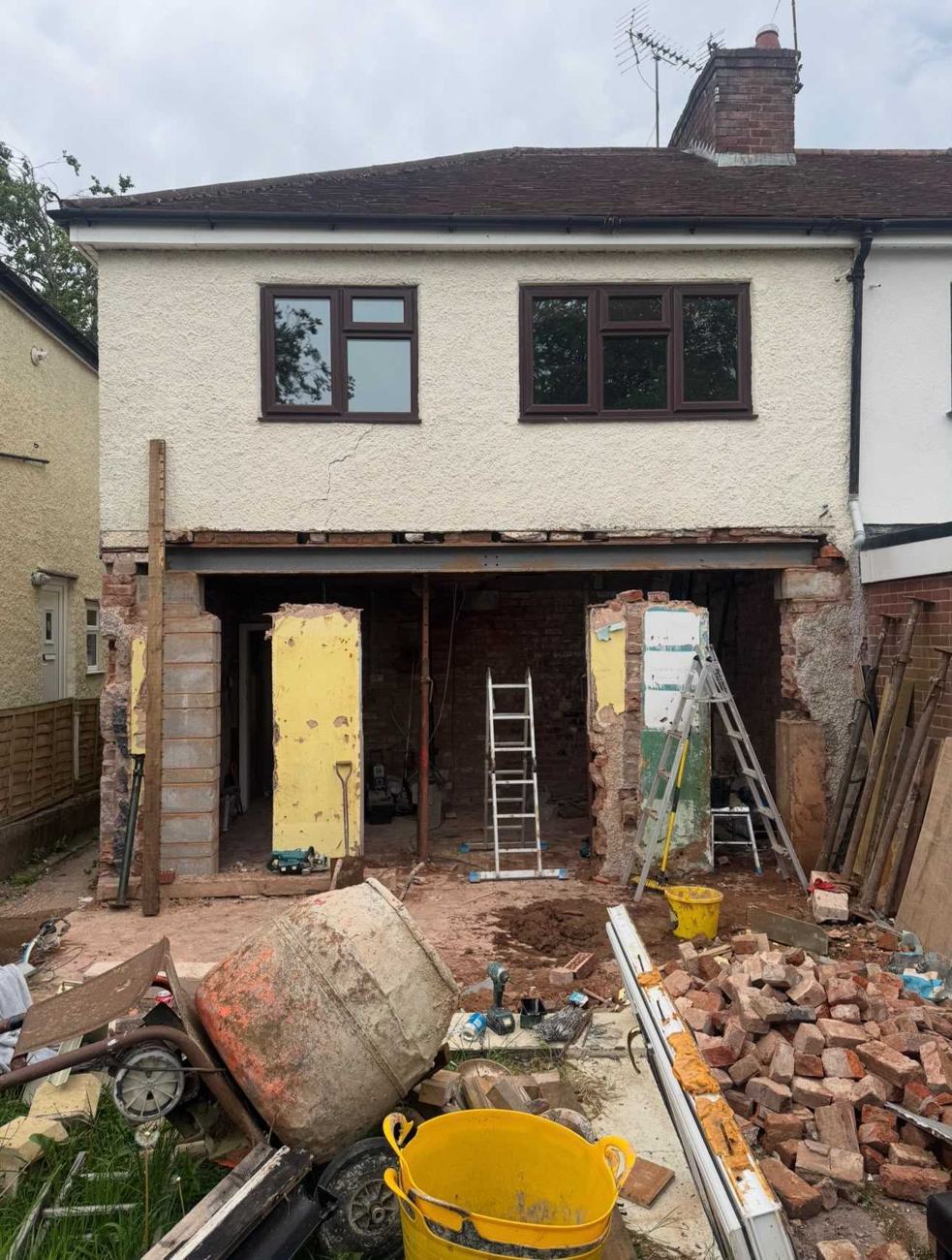 Steel beam in place on temporary props as the rear wall of a semi-detached house is opened up for an extension by DOT Services